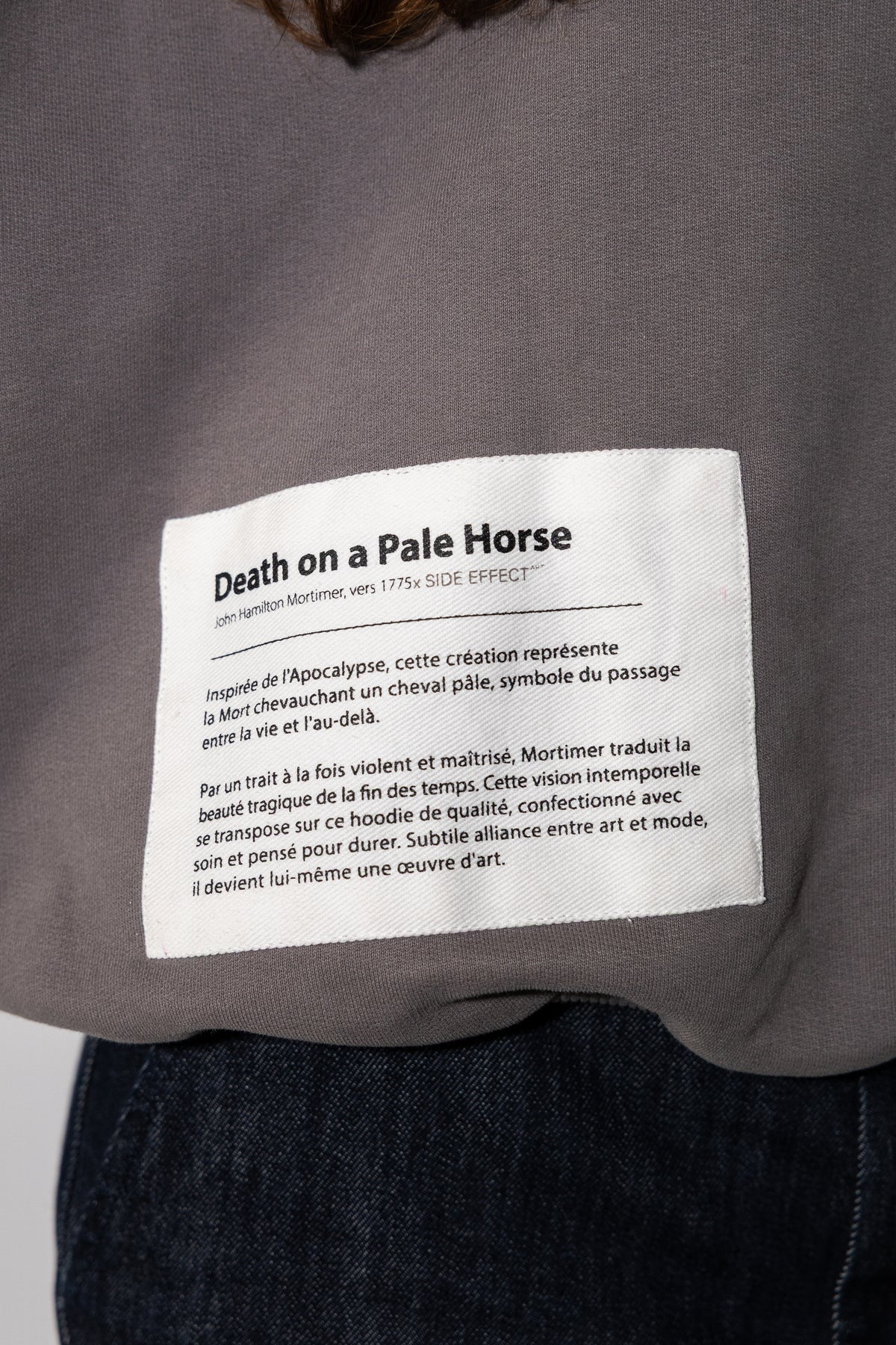 Détail du cartel de musée imprimé sur le devant du hoodie gris