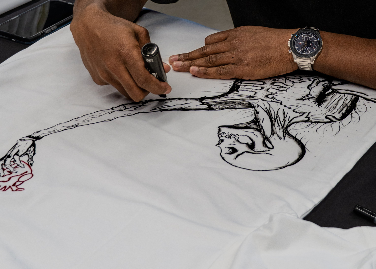 Détail du dessin au feutre sur le t-shirt posé à plat